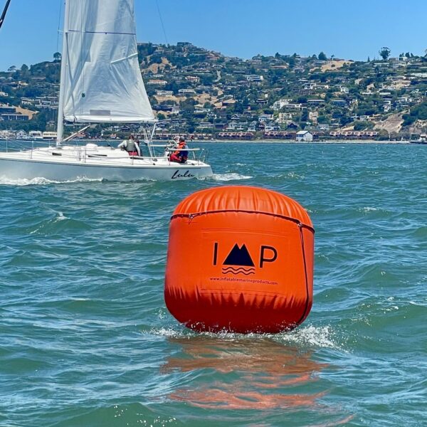 A buoy floating in the water near a boat.