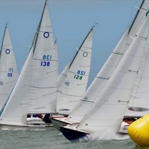 A group of sailboats in the water on a sunny day.
