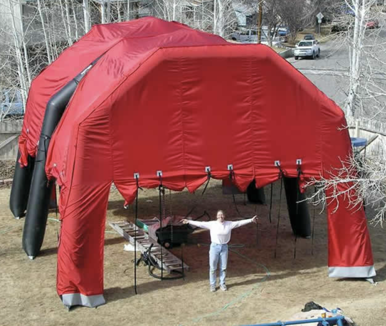 A person standing under an inflatable tent.